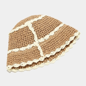 Close-up of retro straw bucket hat with dark khaki weave and white wavy lace details