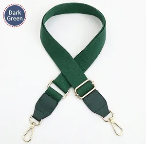 Close-up of adjustable dark green canvas strap with golden alloy hooks and leather ends