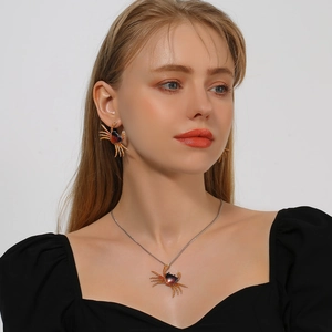 Vista detallada del conjunto de collar y pendientes de cangrejo con esmalte naranja real