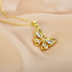 Close-up of golden butterfly pendant with clear crystals and delicate hollow-out design