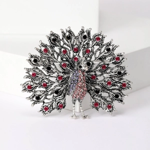 Exquisite peacock brooch in silver metal set with colorful rhinestones on white background