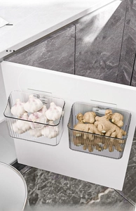 Macro detail of wall-mounted kitchen storage bins filled with fresh ginger and garlic bulbs
