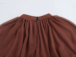 Dettaglio del colletto alla coreana plissettato sull'abito bohémien in chiffon marrone