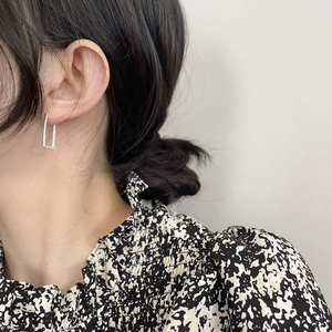 Close-up of minimalist S925 sterling silver geometric square hoop earring worn by a model