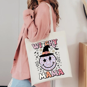 Detail of Witchy Mama Halloween canvas tote bag showing printed leopard smiley face