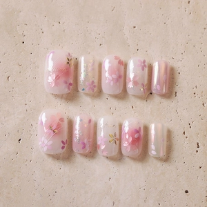 Pink gradient press-on nails set with cherry blossom designs and gold leaf accents