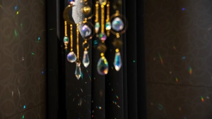Artistic suncatcher with brass moon and crystal prisms casting colorful rainbow patterns