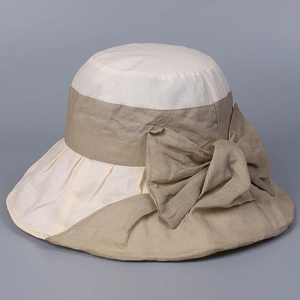 Detail of the elegant bow decoration and breathable linen texture on a sun hat