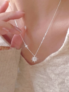 Close-up of 925 sterling silver sunburst pendant necklace with star charms on model