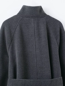 Detail of dark grey twill coat featuring stand collar and back seam construction