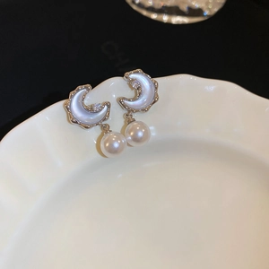 Detail of moon-shaped earrings with blue cat-eye stone, zircon, and round white pearl