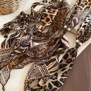 Detail view of assorted animal print chiffon neck scarves with decorative resin beads