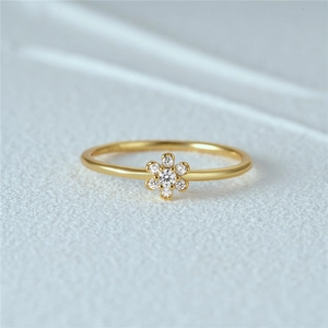 Macro shot of gold S925 silver ring featuring a sparkling diamond flower petal design