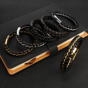 Men's multi-layer braided leather and steel bracelets in assorted colors on a notebook