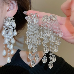 Close-up of luxury silver needle drop tassel earrings with pearls and crystal beads