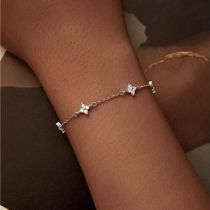 Close-up of elegant silver clover bracelet with cubic zirconia on woman's wrist