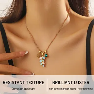 Détail du pendentif arbre de vie doré avec feuille en émail coloré et breloque