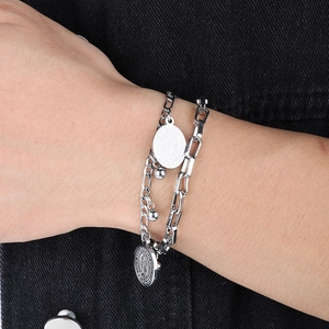 Detailed shot of double-layer stainless steel bracelet featuring Virgin Mary charms