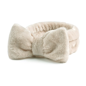 Detailopname van beige koraalvlies hoofdband met een zachte pluche decoratieve strik