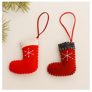 Detail of red knit Christmas stockings with white snowflakes and festive pine branch decor