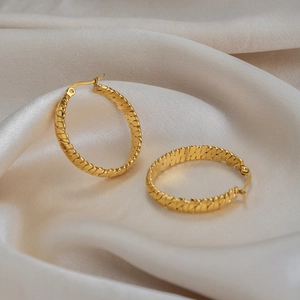 Boucles d'oreilles créoles plaquées or 18 carats avec motif torsadé sur fond en soie
