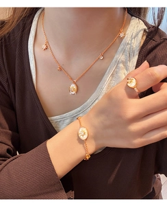Détail de la parure de bijoux en plaqué or 18K avec nacre ovale et pendentifs étoiles