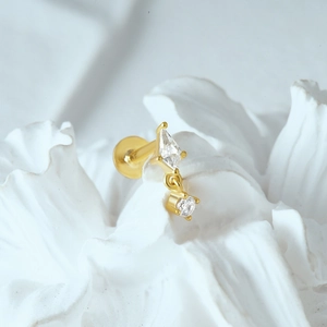 Macro shot of gold S925 sterling silver moon cartilage stud with clear zircons