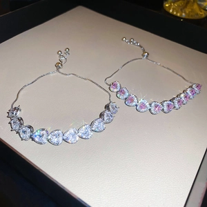 Detailed macro view of heart-shaped pink and white crystal bracelets with bolo clasp