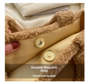 Detail shot of sturdy gold magnetic clasp on a soft khaki plush faux fur handbag