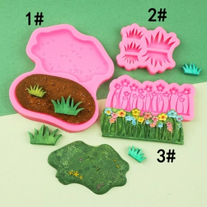 Draufsicht auf drei rosa Silikonformen für Gras und Blumen aus Fondant und Bastelton