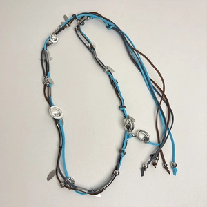 Detail of bohemian suede necklace with blue and brown braided cords and silver metal sequins