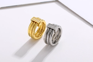 Detail of stacked multi-loop rings in gold and silver finish with micro-set zircon