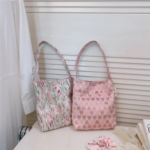Detailed view of floral tulip and pink heart jacquard tote bags with matching scrunchies