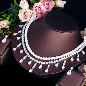 Macro detail of bridal jewelry set with sparkling pear-cut zircons and white pearls