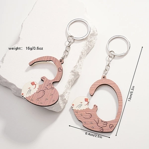 Detailed size specifications of wooden otter couple keychains with measurements shown