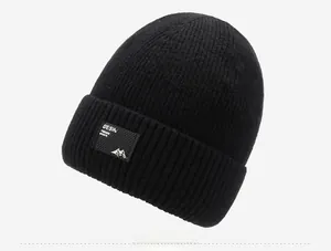 Detail einer schwarzen Strickmütze mit Sport-Logo-Patch und feiner Rippenstruktur