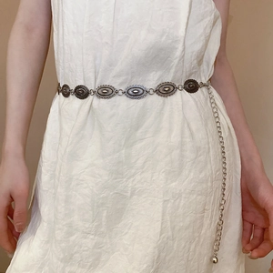 Silver metal chain belt with oval vintage links worn over a cream pleated dress