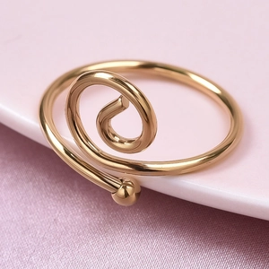 Macro detail of a gold spiral stainless steel ring with a smooth metallic spherical end