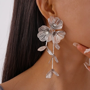 Macro detail of large silver floral tassel earrings with mesh texture on model