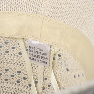Detailed close-up of beige knitted hat interior with sweatband and care label