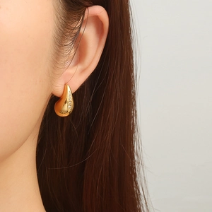 Elegant 18K gold plated teardrop earrings with zircon inlay shown on a female model