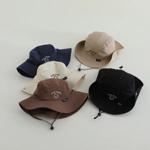 Detail view of children's sun hat featuring adjustable wind ropes and functional side buttons