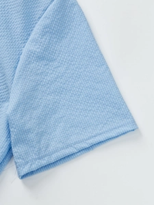 Close-up of light blue seersucker fabric cuff showing unique puckered texture on men's shirt