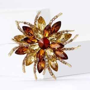 Detail of sunflower brooch featuring a red center stone and amber marquise gems
