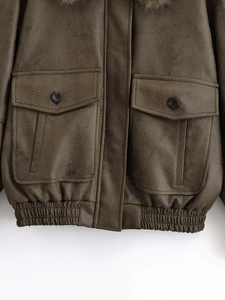 Detail view of dark brown faux leather bomber jacket with large flap pockets and ribbed hem