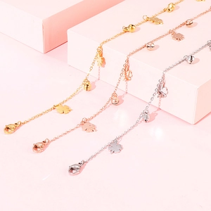 Elegant clover bell anklets in gold, silver and rose gold finishes on pink display
