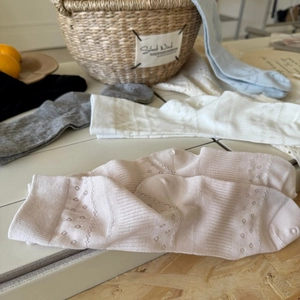 Close-up of retro hollow-out floral pattern on breathable cotton crew socks in pastel colors