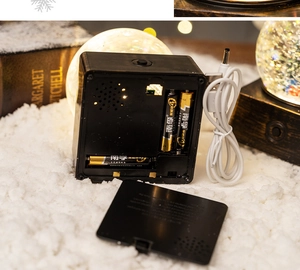 Dual power supply detail for Christmas snow globe with USB cable and battery slot