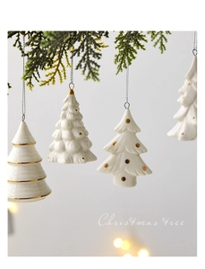 Close-up of white ceramic Christmas tree ornaments with gold accents and hanging cords