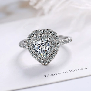 Sparkling zircon heart ring with double halo pavé diamonds on white display card